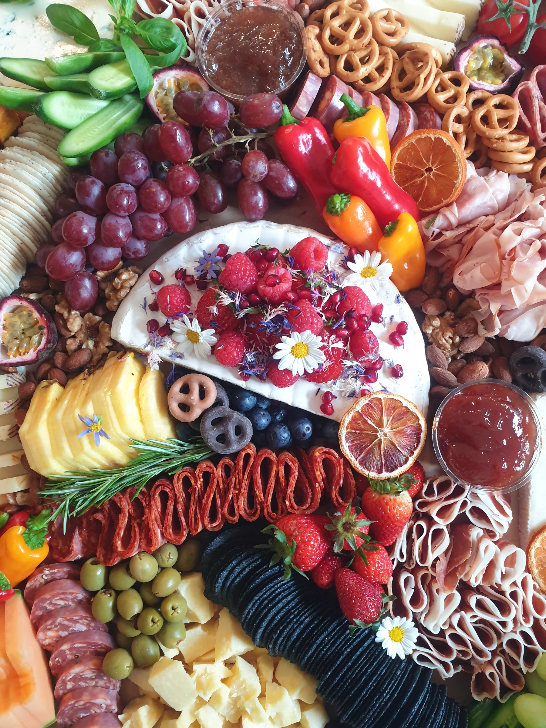 An overhead view of a generous grazing table with cheese, fruit and charcuterie.