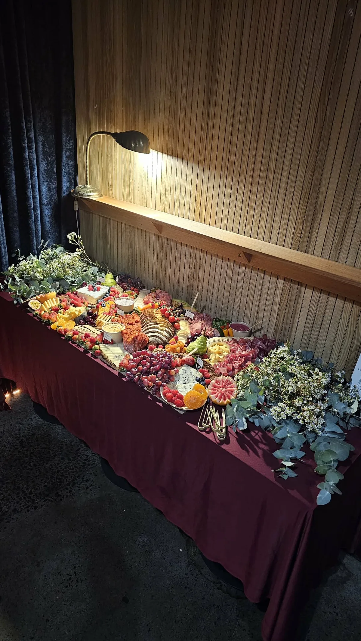A Happy Belly grazing table styled with fruit, cheese and flowers